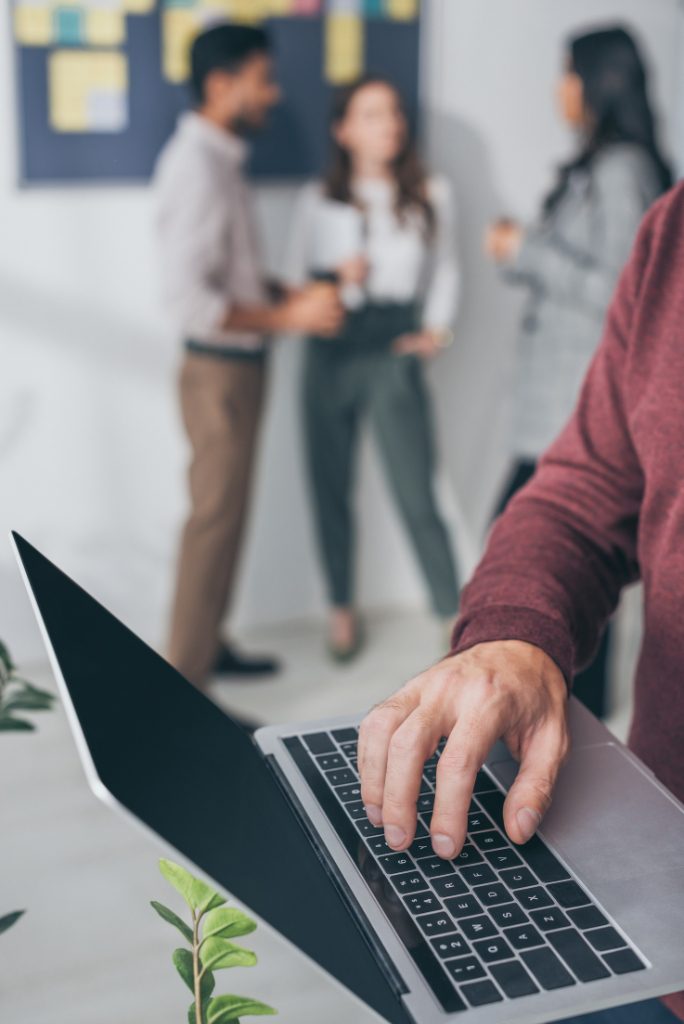 older man on computer with the staff behind him having a discusssion.<br />
